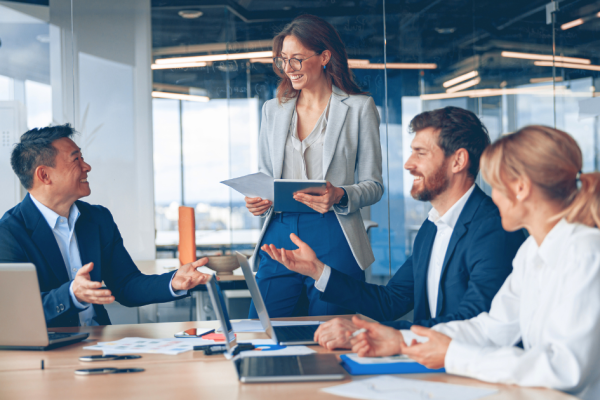 People in an office discuss business while laughing.