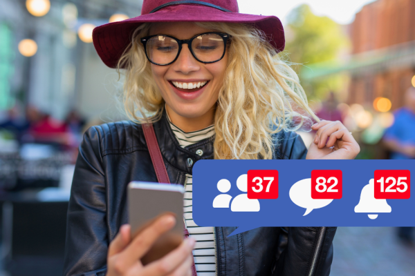 A young woman checks her Facebook feed while walking down the street.