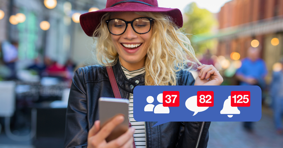 A young woman checks her Facebook feed while walking down the street.
