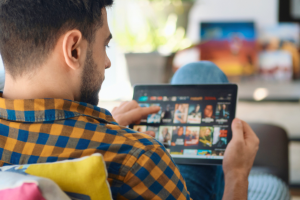 A man browses streaming shows on his tablet.