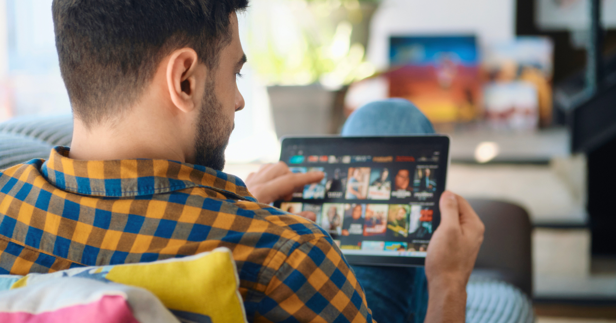 A man browses streaming shows on his tablet.