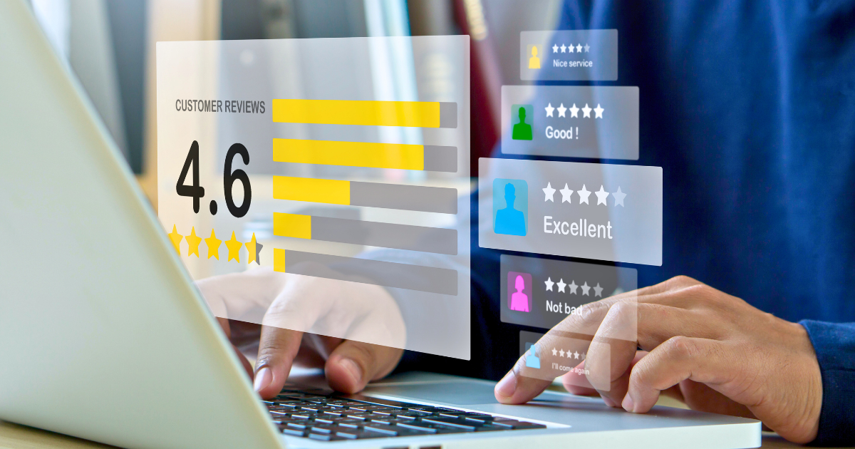 A man sits at his laptop and checks online reviews of his business made by customers.