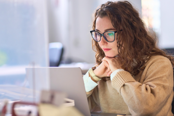 A young woman ponders an Internet search on her laptop computer