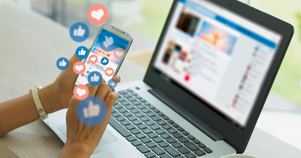 A female social media manager browses her phone and reacts to content while also browsing on her laptop