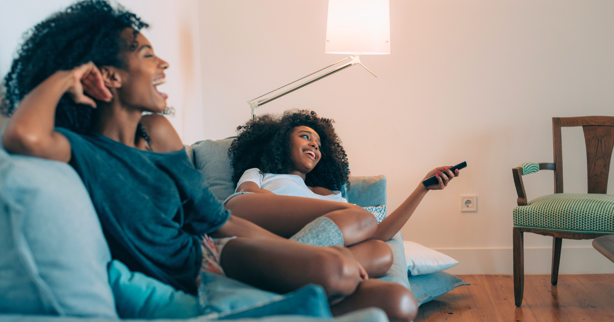 Two young, African American women voters browse television and watch broadcast tv ads.