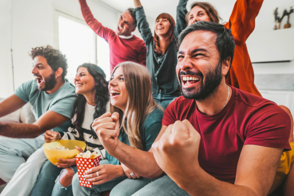 Football fans sit on the couch around the TV and watch uninterrupted streaming ads.
