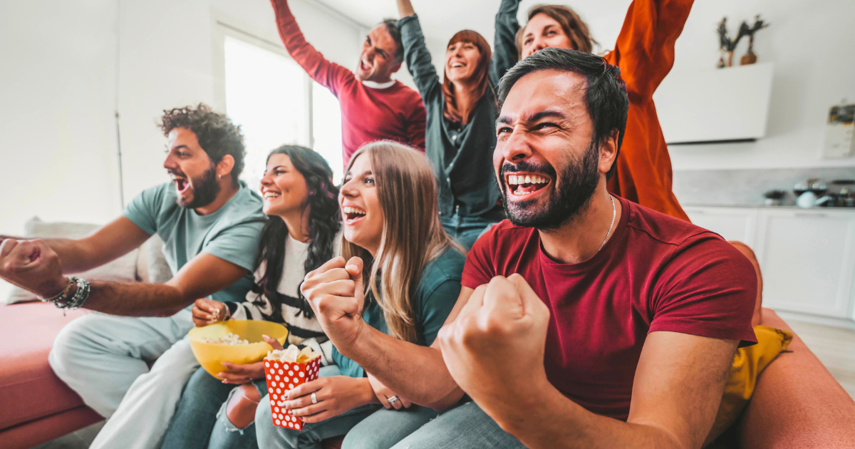 Football fans sit on the couch around the TV and watch uninterrupted streaming ads.