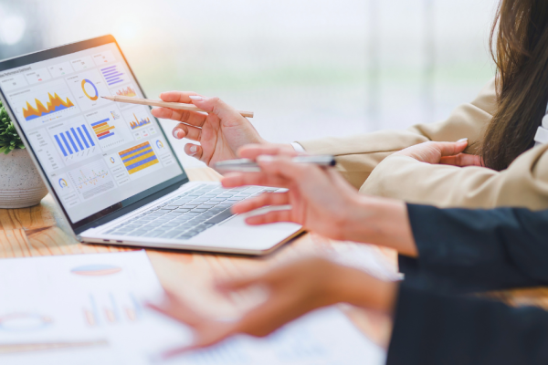 A pair of business people calculate the true roi of their marketing efforts.