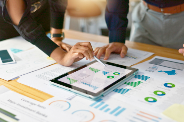 Two business people review their reporting to calculate the ROI of their digital marketing.