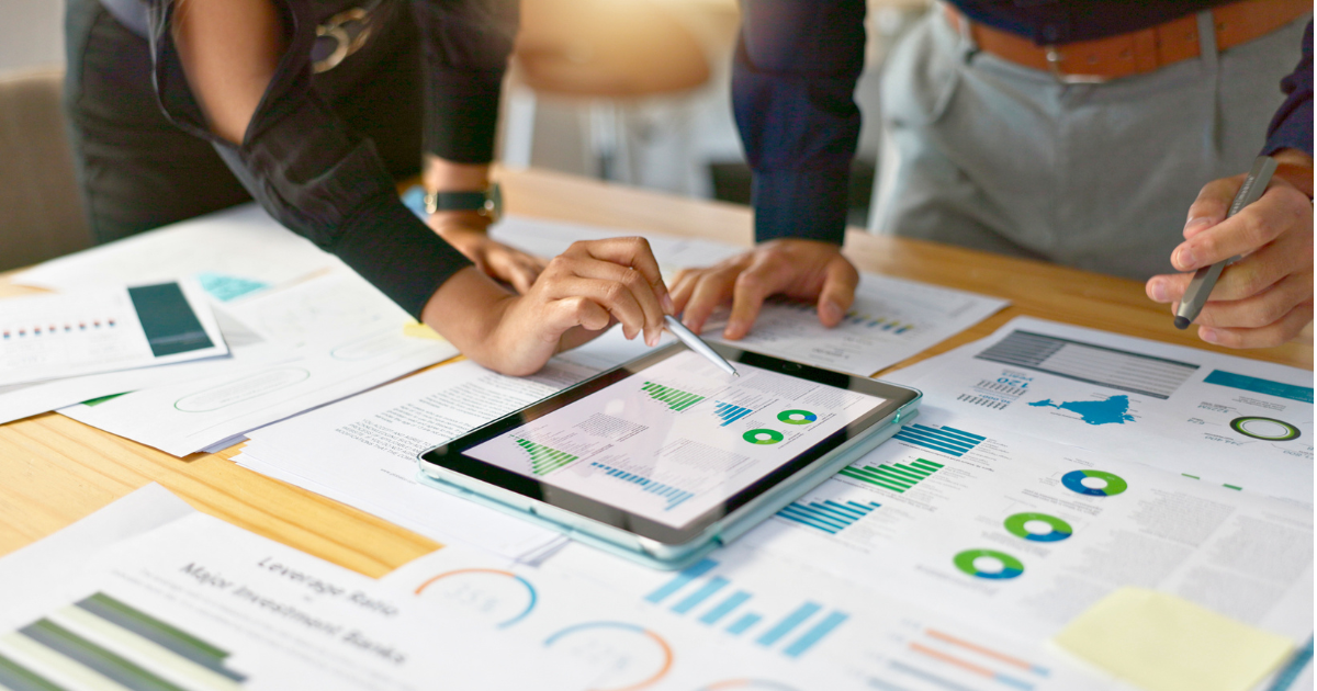 Two business people review their reporting to calculate the ROI of their digital marketing.